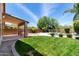 The lush green backyard features a covered patio, grill, and sparkling pool at 4426 E Coyote Wash Dr, Cave Creek, AZ 85331