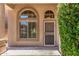 Inviting front entrance showcasing a charming door with security screen, decorative windows, and desert landscaping at 4426 E Coyote Wash Dr, Cave Creek, AZ 85331