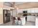 Bright kitchen features stainless appliances, white cabinetry and central island with seating at 4426 E Coyote Wash Dr, Cave Creek, AZ 85331
