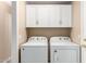 Bright laundry room with white washer, dryer, and upper cabinets for ample storage at 4426 E Coyote Wash Dr, Cave Creek, AZ 85331