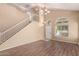 Inviting living room featuring wood floors, staircase, a chandelier, neutral paint, and arched windows at 4426 E Coyote Wash Dr, Cave Creek, AZ 85331
