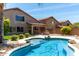 Backyard pool features a rock waterfall, desert landscaping, and a covered patio with grill at 4426 E Coyote Wash Dr, Cave Creek, AZ 85331