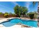 A beautiful pool is showcased surrounded by desert landscape and mature trees at 4426 E Coyote Wash Dr, Cave Creek, AZ 85331