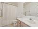 Bright bathroom featuring a single vanity and toilet with a shower curtain covering a tub at 4734 W Golden Ln, Glendale, AZ 85302