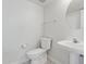 Bright half bath with pedestal sink, elongated toilet, and neutral tile flooring at 4734 W Golden Ln, Glendale, AZ 85302