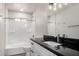 Bright bathroom features a black countertop, white cabinets and a shower with white tile surround at 48451 N 27Th Ave, New River, AZ 85087