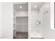 Bright bathroom features a walk in shower with white tile surround and an extra storage shelf at 48451 N 27Th Ave, New River, AZ 85087