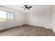 Bedroom boasts wood flooring, ceiling fan, neutral paint, base trim, and a large window with natural light at 48451 N 27Th Ave, New River, AZ 85087