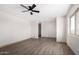 Spacious bedroom featuring wood flooring, neutral walls, base trim, ceiling fan, and ample natural light at 48451 N 27Th Ave, New River, AZ 85087