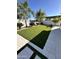 Home backyard features artificial turf, mature trees and clean block fence at 5088 S Ponderosa Dr, Gilbert, AZ 85298