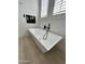 Modern bathtub with sleek fixtures and bright natural light from plantation shutters at 5088 S Ponderosa Dr, Gilbert, AZ 85298