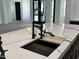 Close up of the kitchen sink and its black and gold water tap, with marble countertops in an open concept kitchen design at 5088 S Ponderosa Dr, Gilbert, AZ 85298
