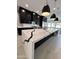 Modern kitchen with a large island featuring white marble countertops with black veins, sleek black cabinets, and pendant lighting at 5088 S Ponderosa Dr, Gilbert, AZ 85298