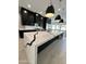 Modern kitchen boasts a large waterfall island with black accents and black cabinets at 5088 S Ponderosa Dr, Gilbert, AZ 85298