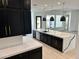 Modern kitchen featuring a large island with white marble countertops and black cabinets, and stainless steel appliances at 5088 S Ponderosa Dr, Gilbert, AZ 85298