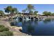 Beautiful waterfall feature flowing into the community lake surrounded by rocks and landscaping at 5088 S Ponderosa Dr, Gilbert, AZ 85298