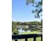 Community pond with a grassy bank and trees, providing a serene, relaxing view with the house in the distance at 5088 S Ponderosa Dr, Gilbert, AZ 85298