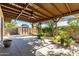 Inviting covered back patio with a ceiling fan, lush greenery, and an outdoor shed at 518 N Cheri Lynn Dr, Chandler, AZ 85225
