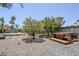 This backyard features a hot tub, gravel landscaping, and mature trees to offer privacy at 5239 E Waltann Ln, Scottsdale, AZ 85254