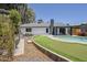 Landscaped backyard featuring a swimming pool, putting green, and modern outdoor living spaces at 5239 E Waltann Ln, Scottsdale, AZ 85254