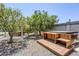 This backyard features mature trees and a covered hot tub with wood deck and gravel landscaping at 5239 E Waltann Ln, Scottsdale, AZ 85254
