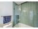Bathroom shower and tub with green tile, clear glass doors and chrome shower head and faucet hardware at 5239 E Waltann Ln, Scottsdale, AZ 85254