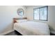 Cozy bedroom with a comfortable bed, white bedding, dark grey flooring and a round mirror above the headboard at 5239 E Waltann Ln, Scottsdale, AZ 85254