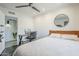 Bedroom with ceiling fan, desk, round mirror, and a comfy bed with white bedding at 5239 E Waltann Ln, Scottsdale, AZ 85254