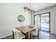 Bright dining area featuring modern lighting, a wooden table, and pool views through sliding glass doors at 5239 E Waltann Ln, Scottsdale, AZ 85254