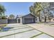 Long driveway that combines concrete and grass leading to a modern gray garage door at 5239 E Waltann Ln, Scottsdale, AZ 85254