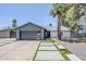 Charming single-story home featuring a modern gray garage door, desert landscaping, and a palm tree at 5239 E Waltann Ln, Scottsdale, AZ 85254