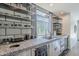 Contemporary kitchen featuring stainless steel appliances, unique countertops, open shelving, and backyard views at 5239 E Waltann Ln, Scottsdale, AZ 85254