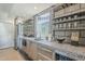 Contemporary kitchen featuring stainless steel appliances, unique countertops, open shelving, and a wine cooler at 5239 E Waltann Ln, Scottsdale, AZ 85254