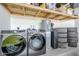 The laundry room features modern appliances, storage shelving, and clean white walls at 5239 E Waltann Ln, Scottsdale, AZ 85254
