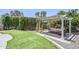 Outdoor pergola with comfortable seating located next to a putting green and privacy hedges at 5239 E Waltann Ln, Scottsdale, AZ 85254