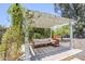 Outdoor pergola with sofa seating on a brick patio under a shade sail and flowering vines at 5239 E Waltann Ln, Scottsdale, AZ 85254