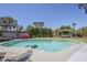 Backyard swimming pool with surrounding landscaping and a covered lounge area with comfortable seating at 5239 E Waltann Ln, Scottsdale, AZ 85254
