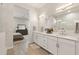 Bright bathroom boasts double sinks with white cabinets and quartz countertops, adjoining bedroom at 5954 E Cat Balue Dr, Phoenix, AZ 85054