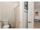 Clean bathroom with neutral tones featuring a toilet, shower with curtain, and coat hooks at 5954 E Cat Balue Dr, Phoenix, AZ 85054