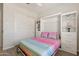 Bedroom with a Murphy bed, colorful bedding, wood-look floors, and shelving; perfect for guests at 5954 E Cat Balue Dr, Phoenix, AZ 85054
