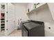 Well-organized laundry room with shelving, front-loading washer/dryer, and ample storage at 5954 E Cat Balue Dr, Phoenix, AZ 85054