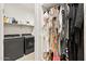 Bright laundry room boasts modern washer, dryer, storage shelves, and organized hanging closet at 5954 E Cat Balue Dr, Phoenix, AZ 85054