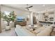 Bright living room with a large tree, comfortable seating, and an open view of the kitchen at 5954 E Cat Balue Dr, Phoenix, AZ 85054