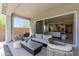 Inviting covered patio featuring comfortable seating, a barbecue grill, and seamless indoor-outdoor living at 5954 E Cat Balue Dr, Phoenix, AZ 85054