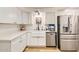 Bright kitchen featuring white cabinetry, farmhouse sink, and stainless steel appliances at 624 N Ashbrook Cir, Mesa, AZ 85213