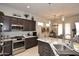 Kitchen area showcasing granite countertops, dark cabinets, and stainless-steel appliances. Open to the dining area at 6937 E Purple Shade Cir, Scottsdale, AZ 85266