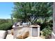 Outdoor kitchen with a built-in grill, stainless steel refrigerator, and mature landscaping at 6937 E Purple Shade Cir, Scottsdale, AZ 85266