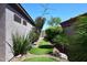 The side yard is landscaped with desert plants, grass stepping stones, and a desert view at 6937 E Purple Shade Cir, Scottsdale, AZ 85266