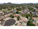 Scenic aerial view showcasing a well-maintained neighborhood with lush landscaping, private pools, and tile roofs at 7315 W Monte Lindo Ln, Glendale, AZ 85310