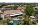 Stunning aerial view of a backyard featuring a pool, tiki hut, covered patio, and lush landscaping at 7315 W Monte Lindo Ln, Glendale, AZ 85310